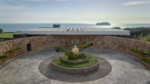 西归浦市JW Marriott Jeju Resort & Spa的一座花园,位于一座带喷泉的建筑前