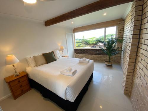科夫斯港Wave Cave Suite的卧室配有一张大白色床和窗户