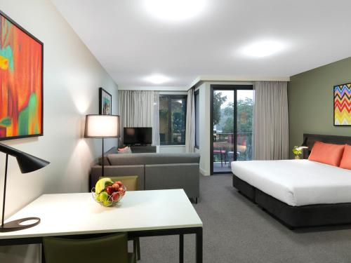 悉尼悉尼机场阿迪纳公寓式酒店的酒店客房,配有床和沙发
