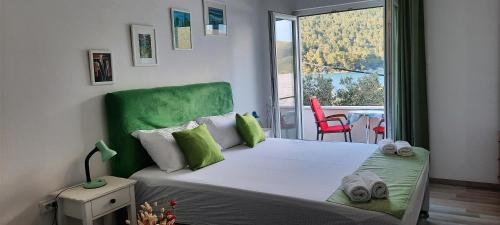 斯顿Apartment Sea Dream的一间卧室配有一张带绿色床头板的床和一个阳台