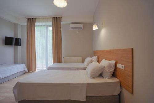 克瓦雷利Tilia Kvareli Resort的酒店客房设有两张床和窗户。