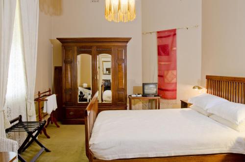 布罗肯希尔帝国精品公寓式酒店的一间卧室配有一张床和一面大镜子