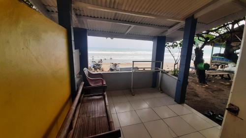 CitepusVilla Family Pantai Citepus Pelabuhanratu的阳台设有长凳,享有海滩美景。