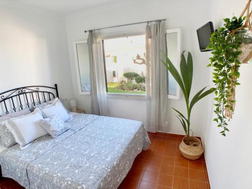 蓬塔格罗萨La Casa del Jardin. Menorca的一间卧室设有一张床和一个窗口