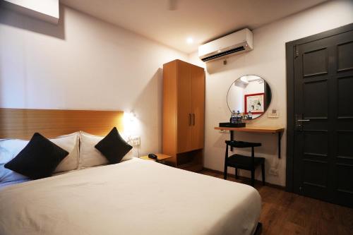乌代浦Hotel Townhouse的一间卧室配有一张床、一张书桌和一面镜子