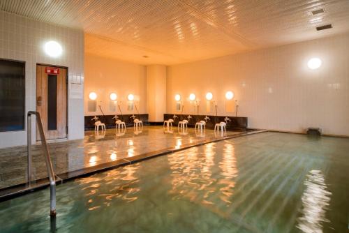 沼津沼津哈马宇日式旅馆的健身房内一个带一排椅子的游泳池