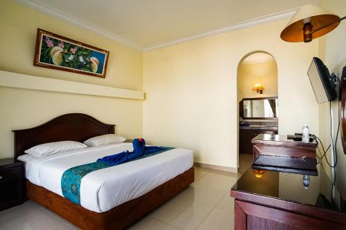 勒吉安Taman Ayu Legian Hotel的酒店客房带一张床和一架钢琴