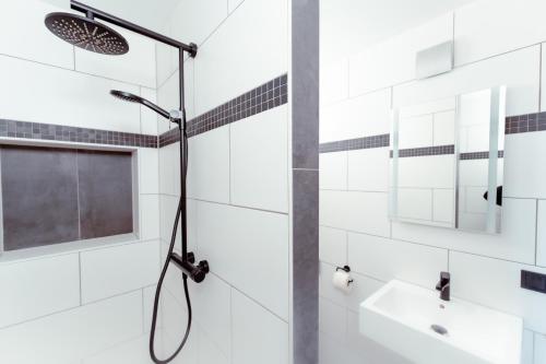德累斯顿Restaurant und Pension Alberthafen的浴室铺有白色瓷砖,设有淋浴。