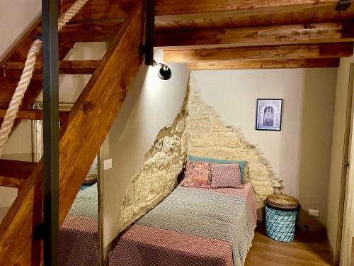 拉古萨A Timpa ro Nannu 20, Holiday Home in Center Ragusa IBLA的一间带双层床的卧室,位于带楼梯的房间