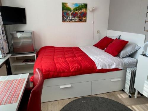 PoortugaalValckesteyn的一间卧室配有红色的床和电视