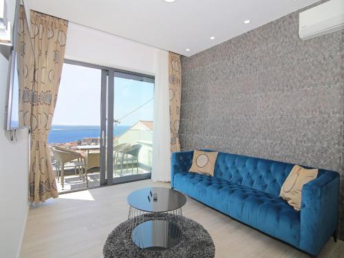 杜布罗夫尼克Luxury Amarin Apartment的客厅配有蓝色沙发,享有海景