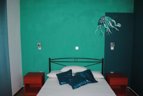 阿凡杜Karmik Concept Apartments的一间卧室设有蓝色的墙壁和一张带两个枕头的床