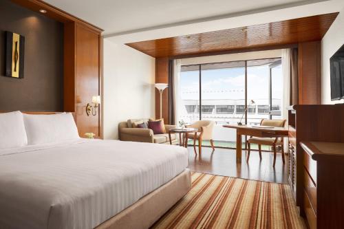 曼谷曼谷阿玛瑞廊曼机场酒店的酒店客房 - 带一张床和用餐室