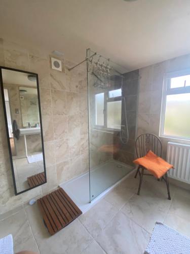 切尔滕纳姆Zen Cottage, Cheltenham的带淋浴、椅子和镜子的浴室