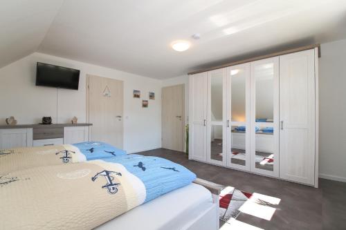 诺德代希Ferienwohnungen Gatena的一间卧室配有一张大床和电视