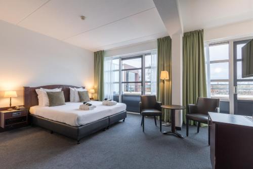 阿尔克马尔阿尔克马尔阿姆拉斯酒店的一间卧室配有一张床、两把椅子和窗户
