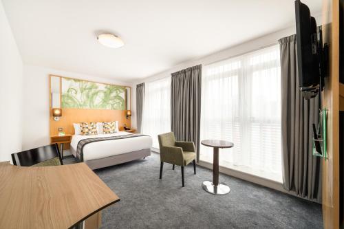 伯明翰假日伯明翰城市酒店度假村的酒店客房配有一张床铺和一张桌子。