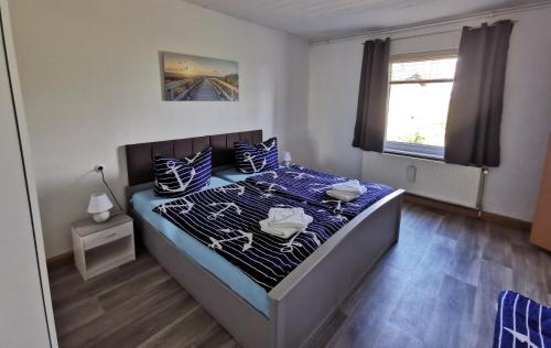 GarzFerienwohnung Am Stadtrand Garz Rügen的一间卧室配有一张带蓝色和白色枕头的床