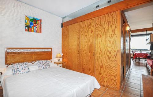 圣普里安海滩1 Bedroom Awesome Apartment In St Cyprien的一间卧室设有一张床和木墙