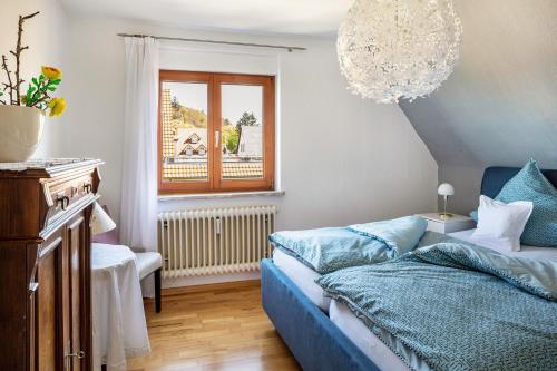 SexauFerienwohnung Trixi的一间卧室配有蓝色的床和吊灯。