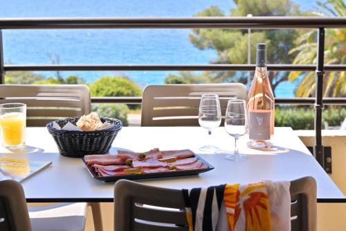 阿雅克修加兰克酒店的一张桌子,上面放着一盘食物和一瓶葡萄酒
