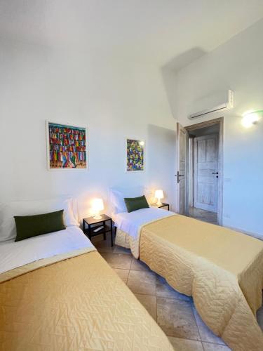 圣特奥多罗Appartamento La Conchiglia a pochi passi dal centro的两张床铺位于带两盏灯的房间