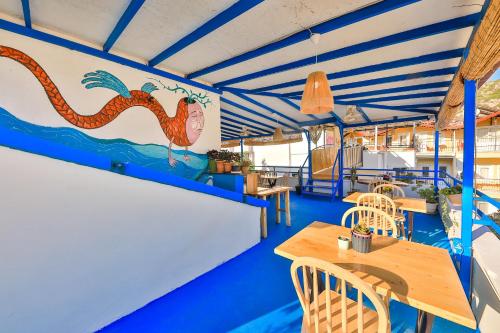 安塔利亚Bahar Pansiyon的海鲜餐厅设有桌子和壁画