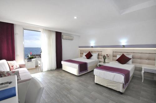 阿萨拉尔Ramira Beach Hotel - All Inclusive的酒店客房,设有两张床和一张沙发