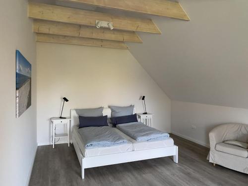 费马恩Fischerhus的一间卧室配有白色床和蓝色枕头