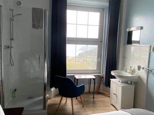 林顿西奈之家酒店的带淋浴、蓝椅和水槽的浴室