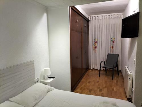 埃尔切Piso Centro María Aire-Wifi的一间卧室配有一张床和一把椅子