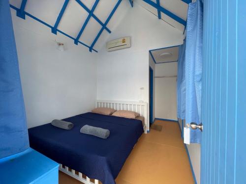 班泰Ko Phangan Beach Cottages的小房间设有两张床和蓝色窗帘