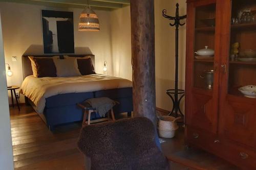 尼温迪普Landelijk gelegen appartement met eigen ingang的一间卧室配有一张床和一把椅子