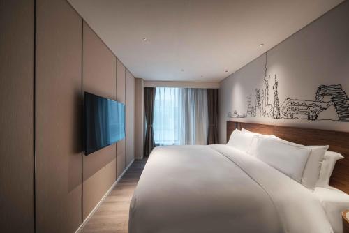 上海上海陆家嘴世博中心逸扉酒店的一张大白色的床,位于酒店客房内