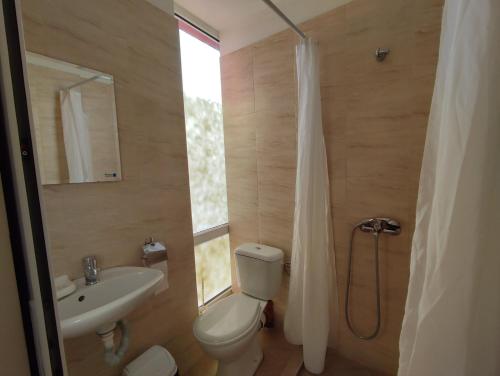 阳光海滩Hotel Seasons 2的浴室配有卫生间、盥洗盆和淋浴。