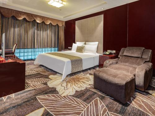 长沙Days Hotel & Suites China Town - Metro Line 2 - Nearby Wuyi Square ,Orange Island,Hunan Museum的配有一张床和一把椅子的酒店客房