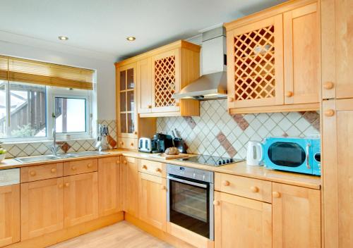 阿伯索赫Kookaburra的厨房配有木制橱柜和蓝色微波炉
