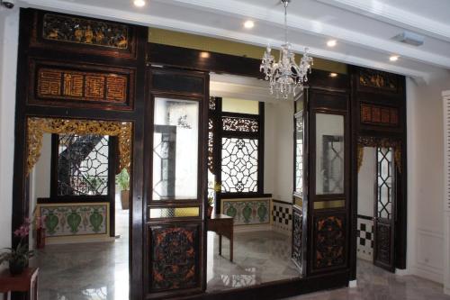 马六甲希伦棕榈套房酒店的一间设有木门和吊灯的客房