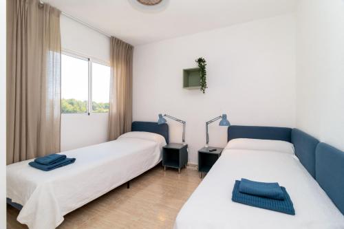 奥里韦拉Espanatour CAMPOAMOR的客房设有两张床和窗户。