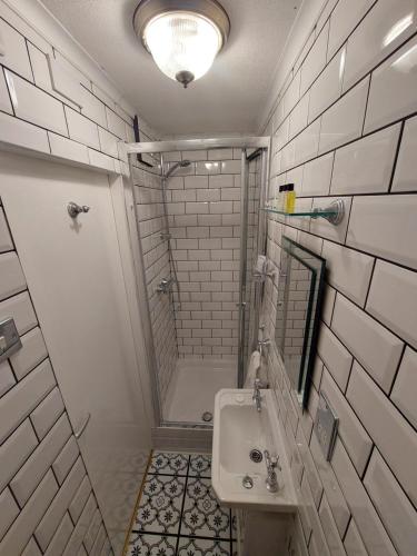 布莱克浦Westfield House的带淋浴和盥洗盆的白色浴室