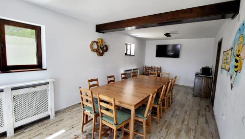 克利默内什蒂Casa Albinuța的一间带木桌和椅子的用餐室
