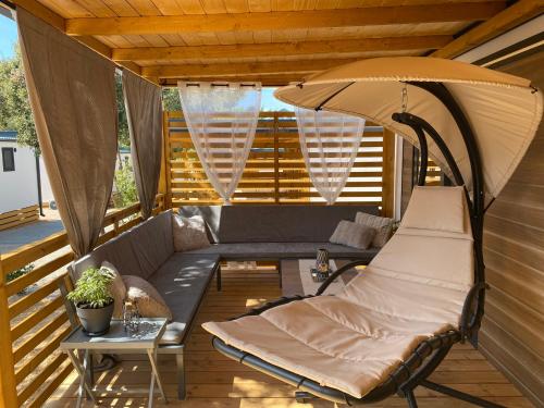 比奥格勒·纳·莫鲁Mobile Home Saky, Camp Soline的一个带沙发和雨伞的门廊