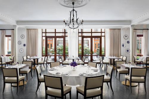 华沙华沙布里斯托尔豪华精选酒店的一间带桌椅和吊灯的用餐室