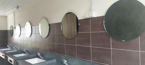 罗纳河畔的图尔农Camping les Sables的浴室设有3个水槽和墙上的镜子