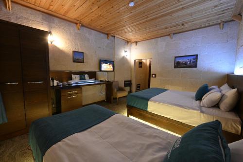 乌奇希萨尔卡帕多西亚亚丁酒店的酒店客房配有两张床和一张书桌