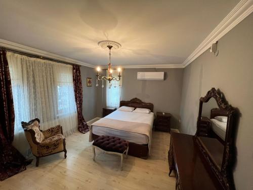 ÇağlayanVilla trabzon的一间卧室配有一张床、一把椅子和一个吊灯。