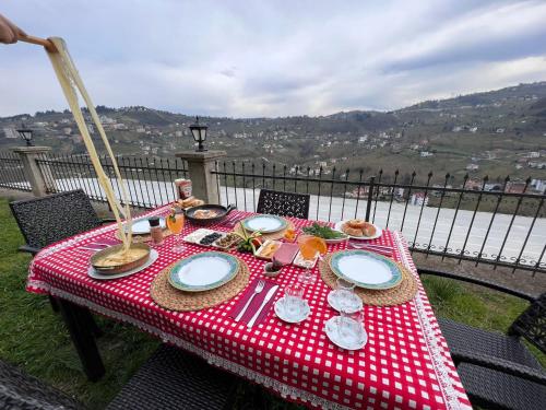 ÇağlayanVilla trabzon的一张桌子,上面有红色和白色的桌布,上面有食物