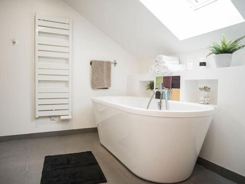 Nâves-ParmelanVenez Chez Vous - Le Cocon du Parmelan的带窗户的浴室内的白色浴缸