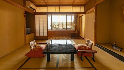 加贺富士屋旅馆的客房设有桌子、两把椅子和窗户。