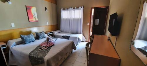 维拉卡洛斯帕兹Hotel Sebari的酒店客房设有两张床和电视。